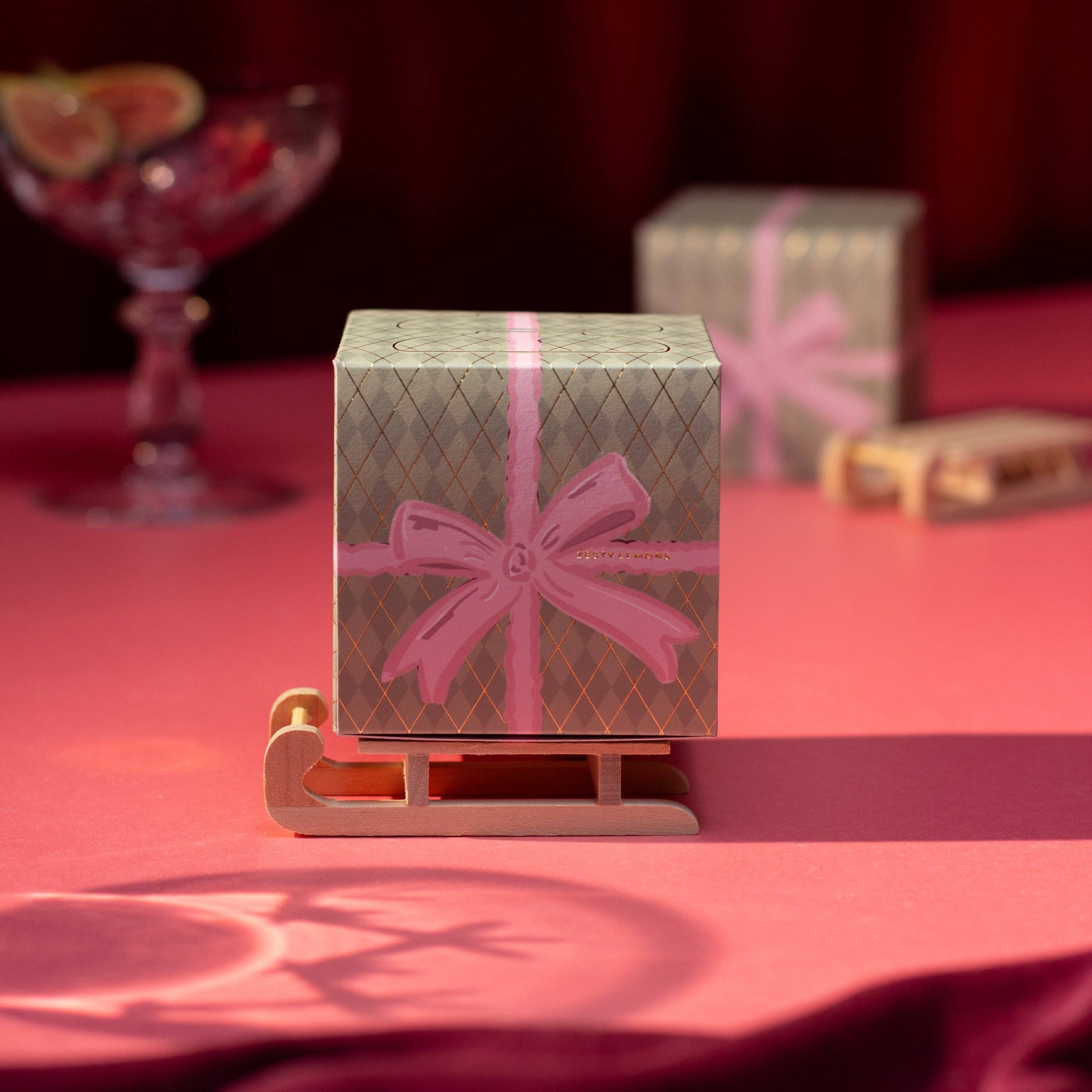 Coffret bougies Christmas Bow Zesty Lemons — deux bougies chauffe-plat en céramique parfum Myrrhe & Tonka, boîte cadeau avec nœud rose et traîneau en bois