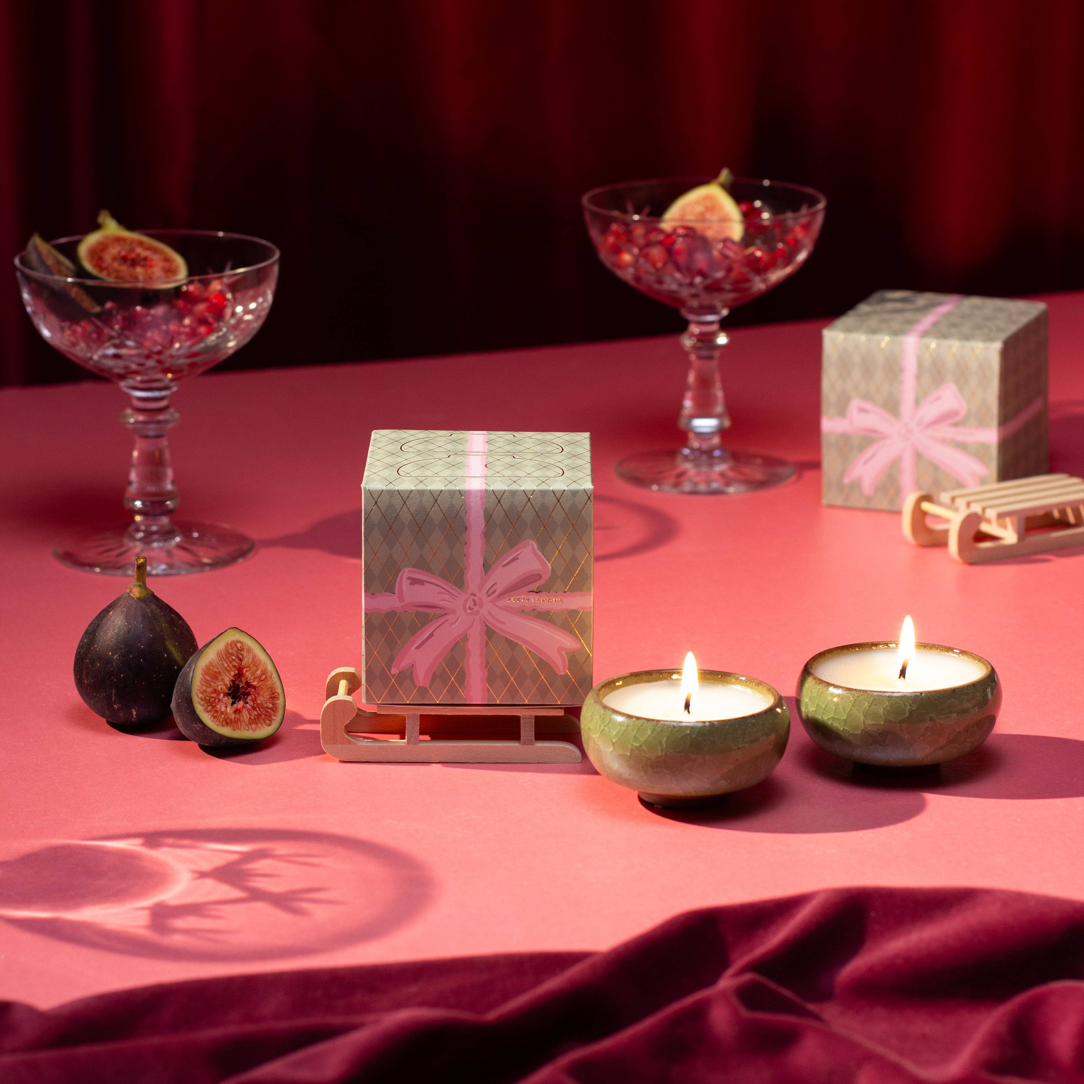 Coffret bougies Christmas Bow Zesty Lemons — deux bougies chauffe-plat en céramique parfum Myrrhe & Tonka, boîte cadeau avec nœud rose et traîneau en bois