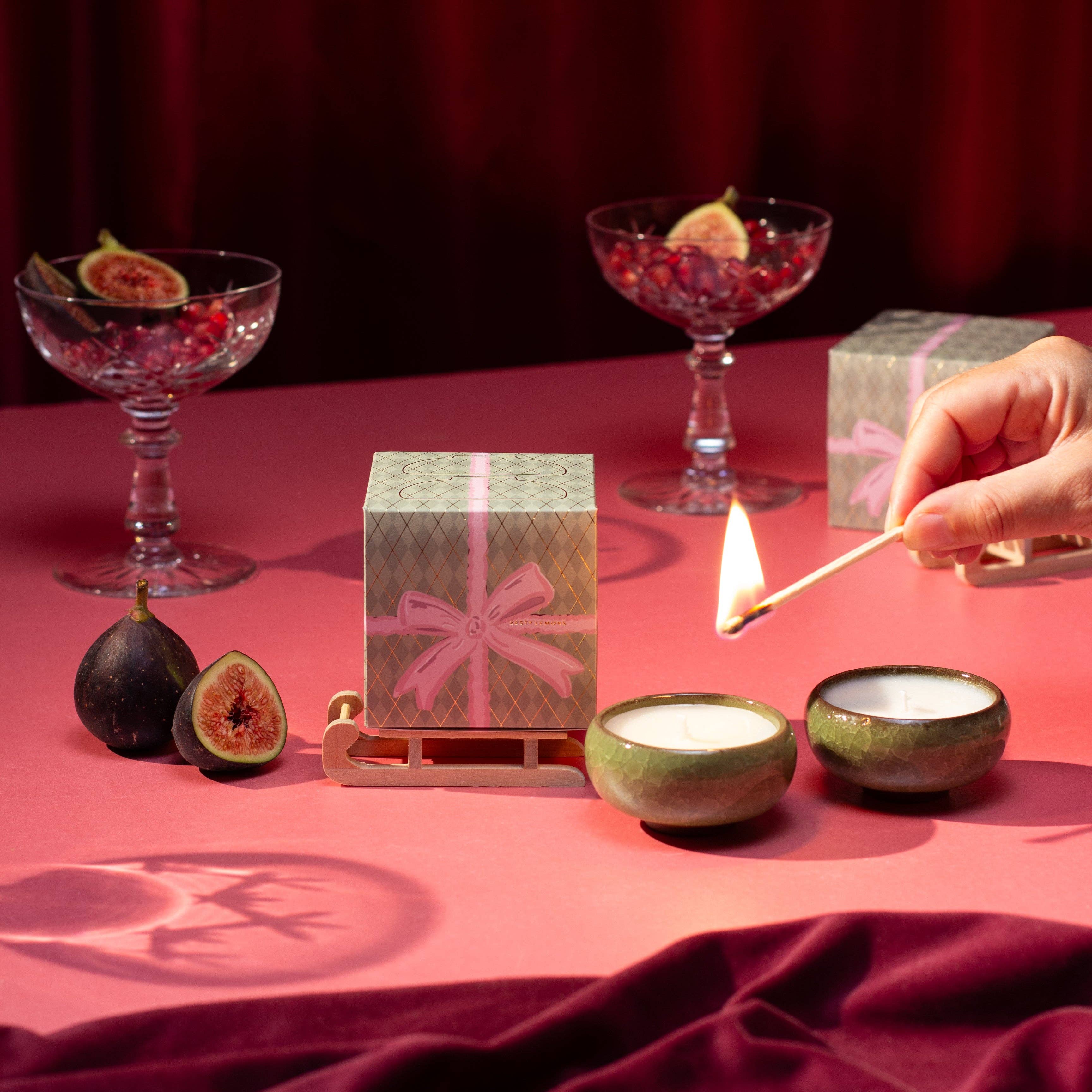 Coffret bougies Christmas Bow Zesty Lemons — deux bougies chauffe-plat en céramique parfum Myrrhe & Tonka, boîte cadeau avec nœud rose et traîneau en bois