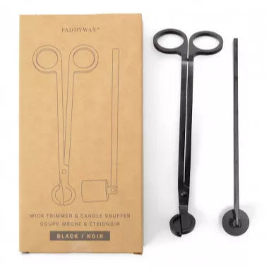 Coffret PADDYWAX avec éteignoir et coupe-mèche en métal noir mat, posé à côté d’une bougie – accessoire chic pour rituel bougie.