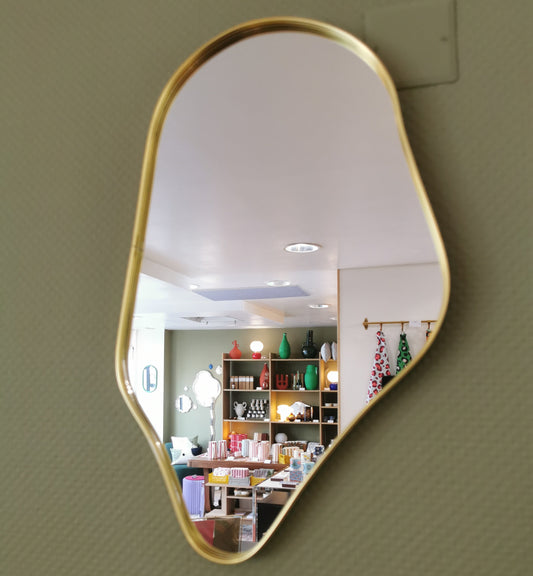 Miroir de forme organique, bord en métal doré.
